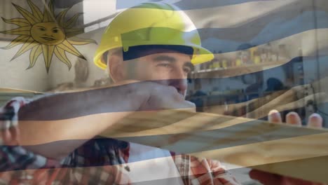 bandera de uruguay sobre trabajador del sitio que lleva una viga de madera.