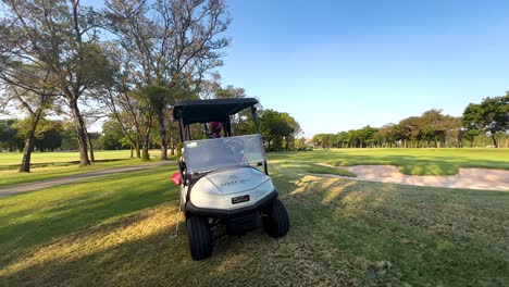 golf cart moving through scenic golf course