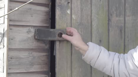 mujer asegurando fuera de la puerta del cobertizo