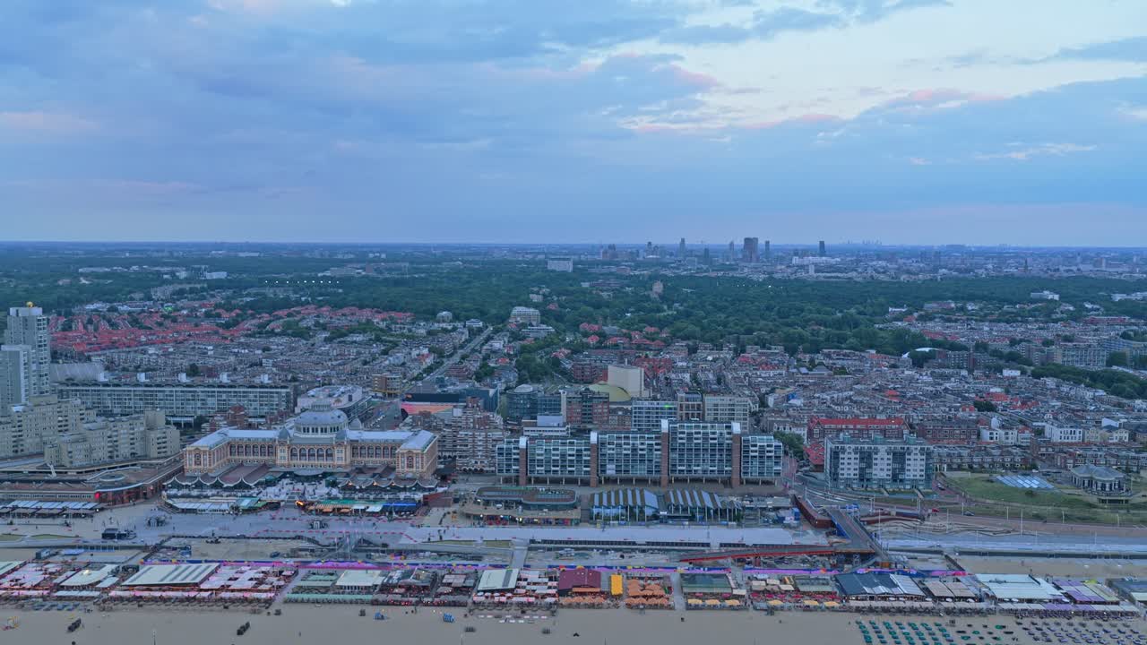 Scheveningen Strand med byens bygninger i skumringen, luftfoto i den gyldne time, Holland
