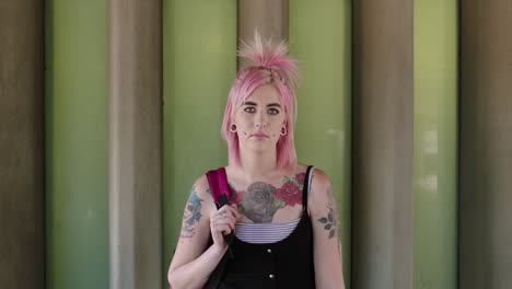 portrait of eccentric young woman with tattoo body piercing looking serious