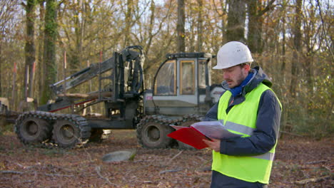 forest clearing heavy machinery, employee reviewing detailed report