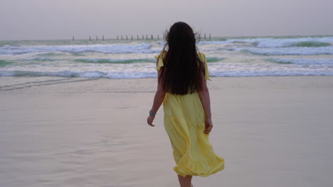 Girl-walking-towards-sea-in-Dubai,-Persian-gulf