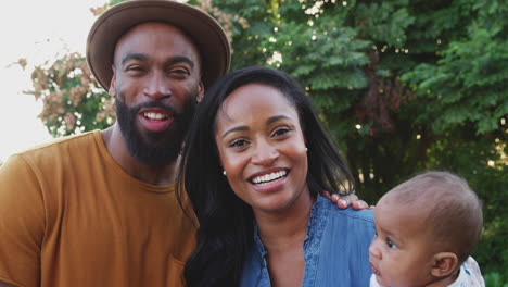 retrato de una familia afroamericana con su hija relajándose en el jardín en casa juntos