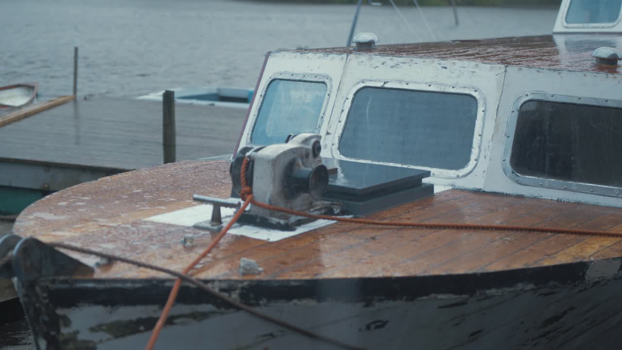 Bow of eighty year old forty foot wooden Seaplane Tender boat moored up during bleak weather