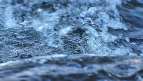 slow motion close-up of a freshwater mountain stream in northumberland, uk. bubbling rapids and swirling details in a clear, dynamic flow