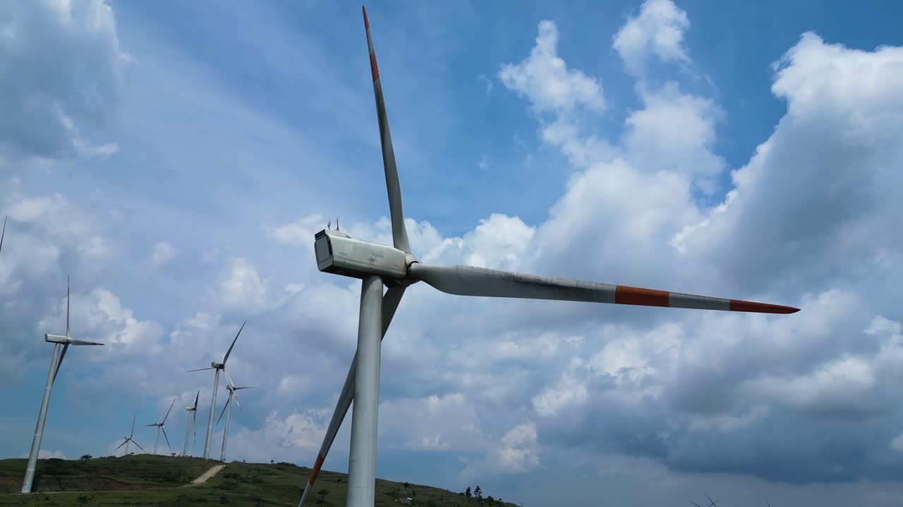 Wind turbines over green hills, sustainable investment in global renewable energy sector