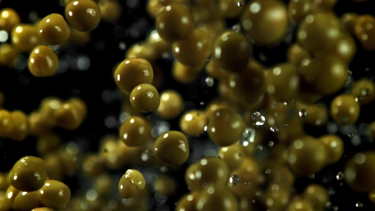 Piselli verdi freschi che cadono in super slow motion con goccioline d'acqua