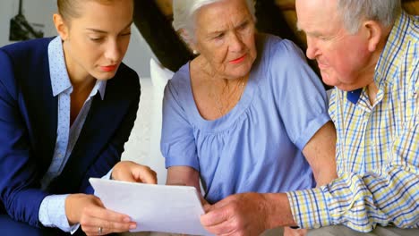 front view of old caucasian senior couple interacting with real estate agent at home 4k