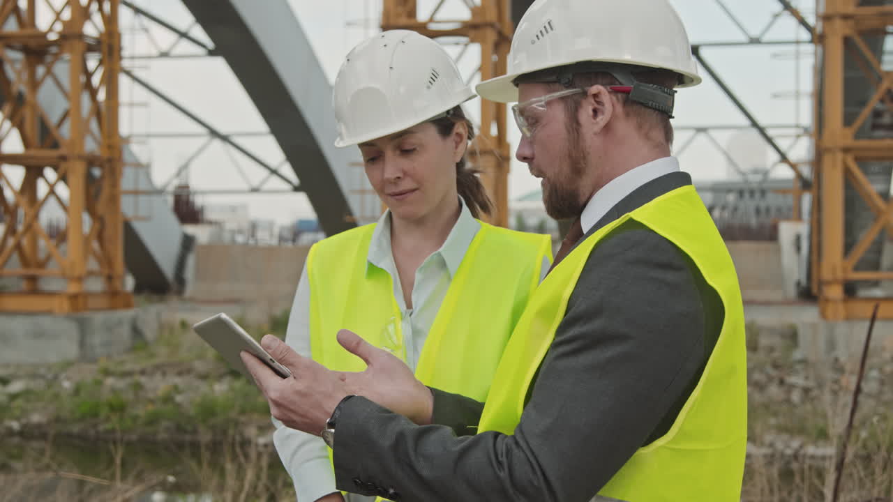 Male Site Supervisor Discussing Work with Colleague