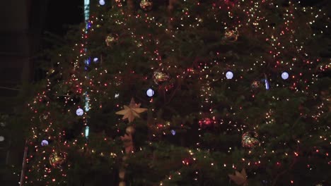 close up of christmas tree lights and decorations at night. pedestal shot