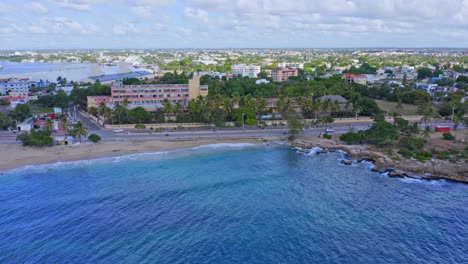 aerial trucking shot of malecon san pedro de macoris with beautiful shoreline,coastal road and scenery