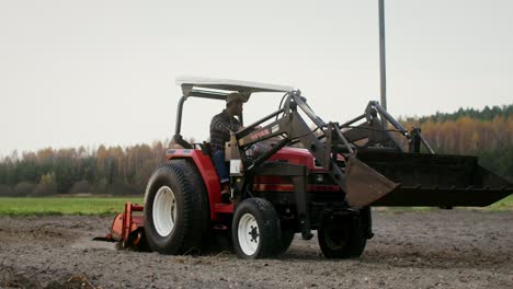 agricultor que maneja un tractor en un campo