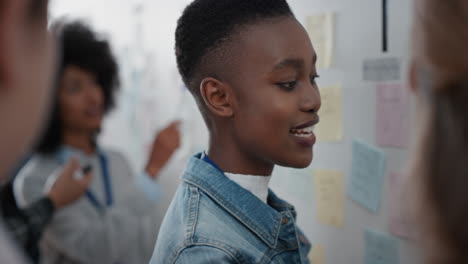 african american business woman using sticky notes brainstorming with colleagues in meeting team leader sharing creative problem solving ideas for solution enjoying teamwork in startup office