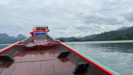 panning right to left, the camera captures the front of a speeding boat on a lake, showcasing its swift movement through the water