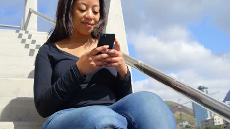 mujer hermosa usando teléfono móvil en las escaleras 4k