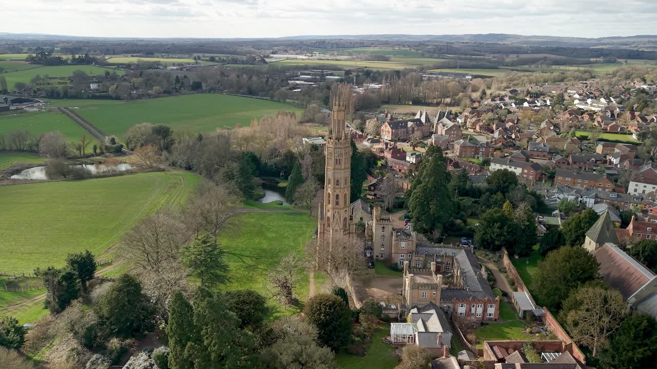 Historic Hadlow Tower rises among houses of Kent village in aerial view of cultural landscape