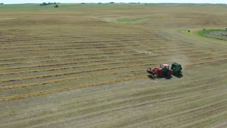 Traktor-Sammelt-Trockenes-Gelbes-Heu-Mit-Ballenpresse-Auf-Großem-Ackerland,-Antenne