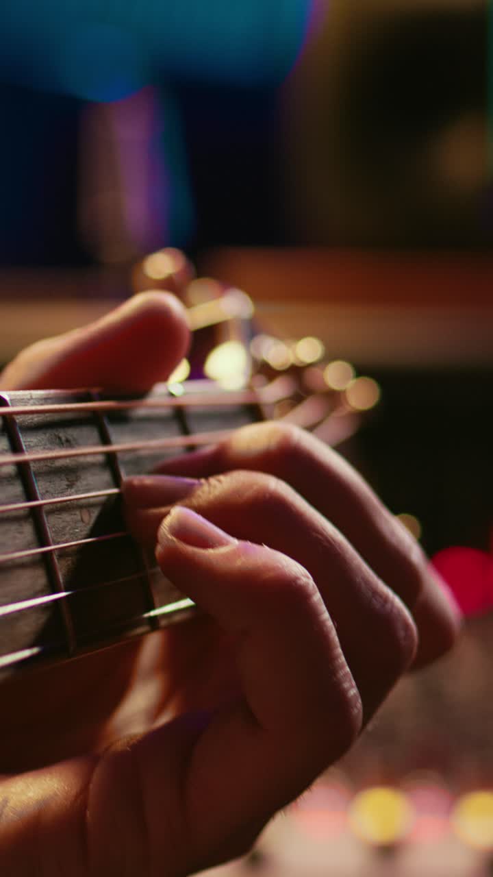 Close-up of Hand Playing Acoustic Guitar with Bokeh Lights