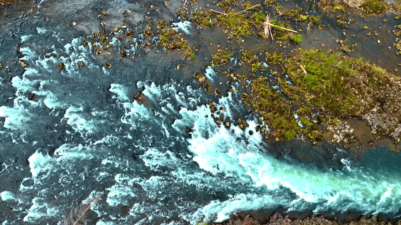 Quickly flowing river with numerous rapids. Top view on the mountainous river from drone.