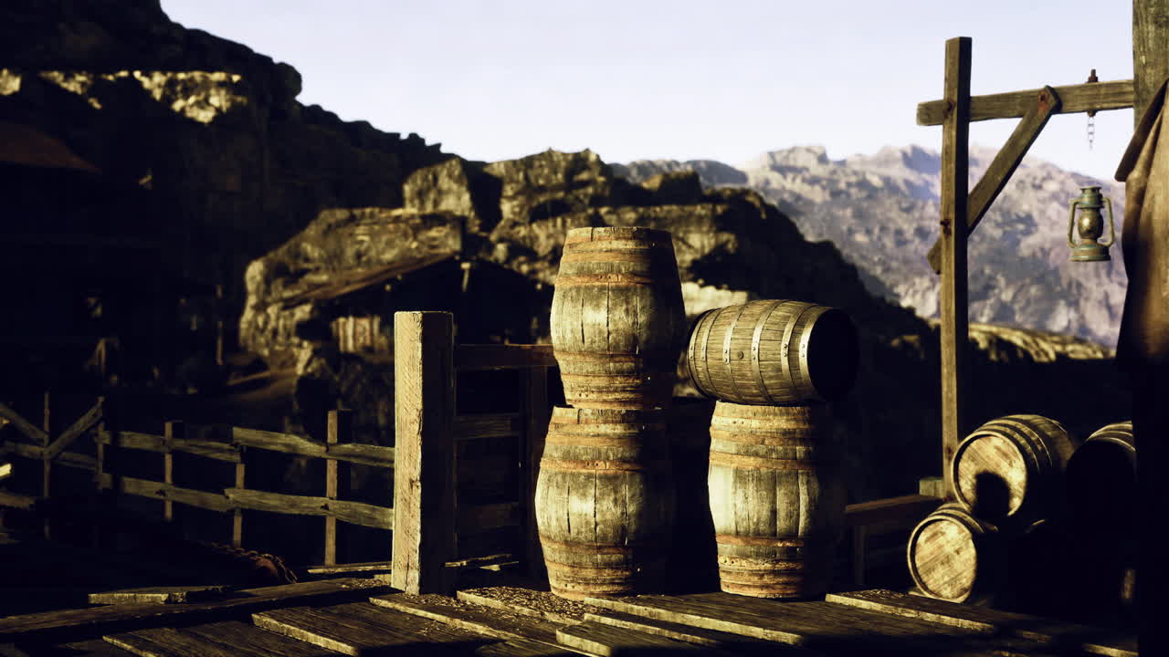 Wooden barrels near a rustic wooden structure in a mountainous landscape