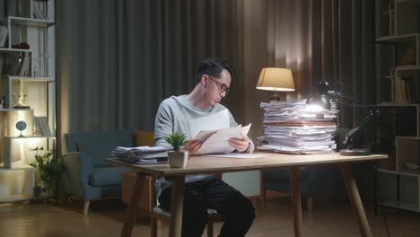 hombre estresado trabajando hasta tarde en casa