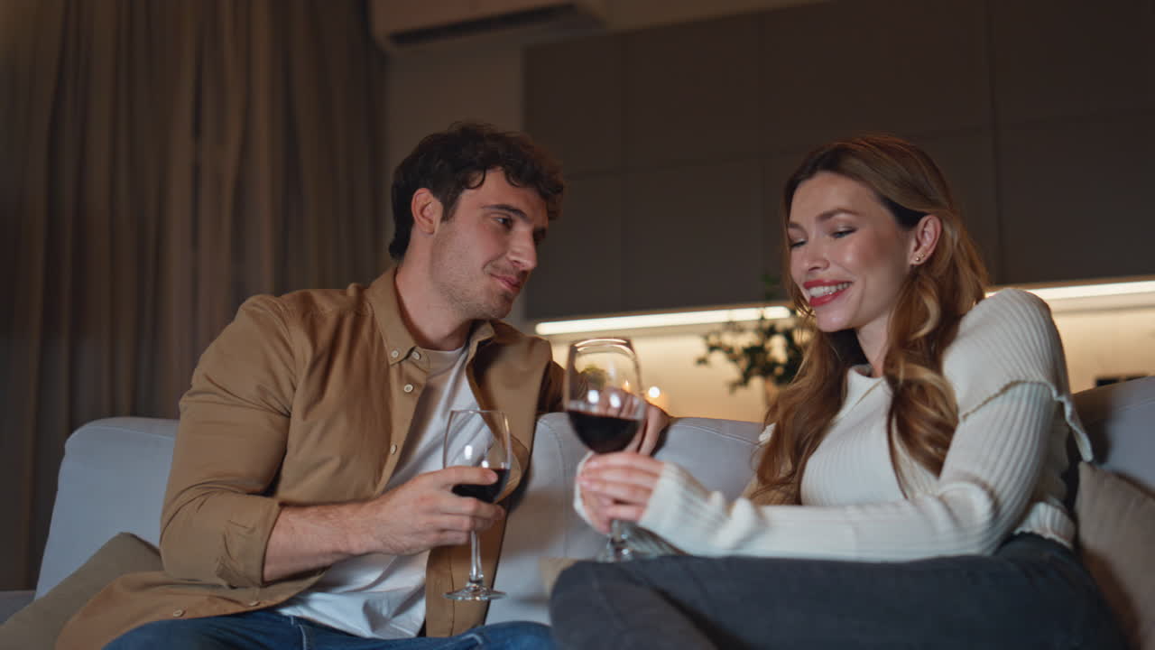 Smiling lovers relaxing couch holding wine glasses close up. Romantic couple