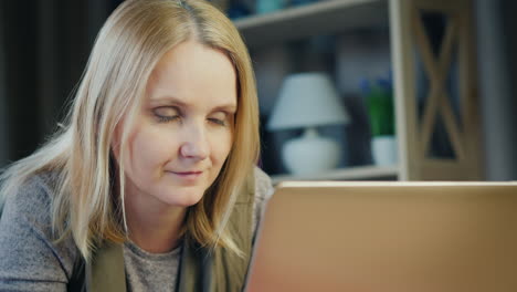 A-middle-aged-woman-uses-a-laptop-on-her-bed-4