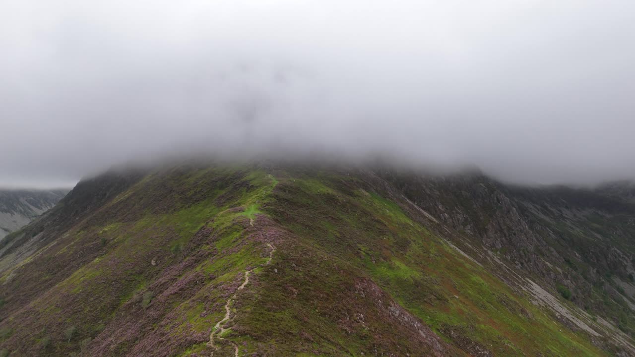 Drone footage of a misty descent of wainright Fleetwith Pike's craggy ridge in the Lake District National Park