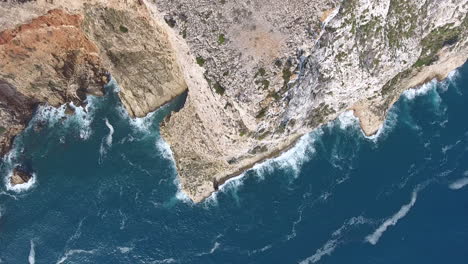 aerial view of cape san antonio, denia, valencia. rocky cliff revealing sea waves crushing on the coastline. blue water in a sunny day