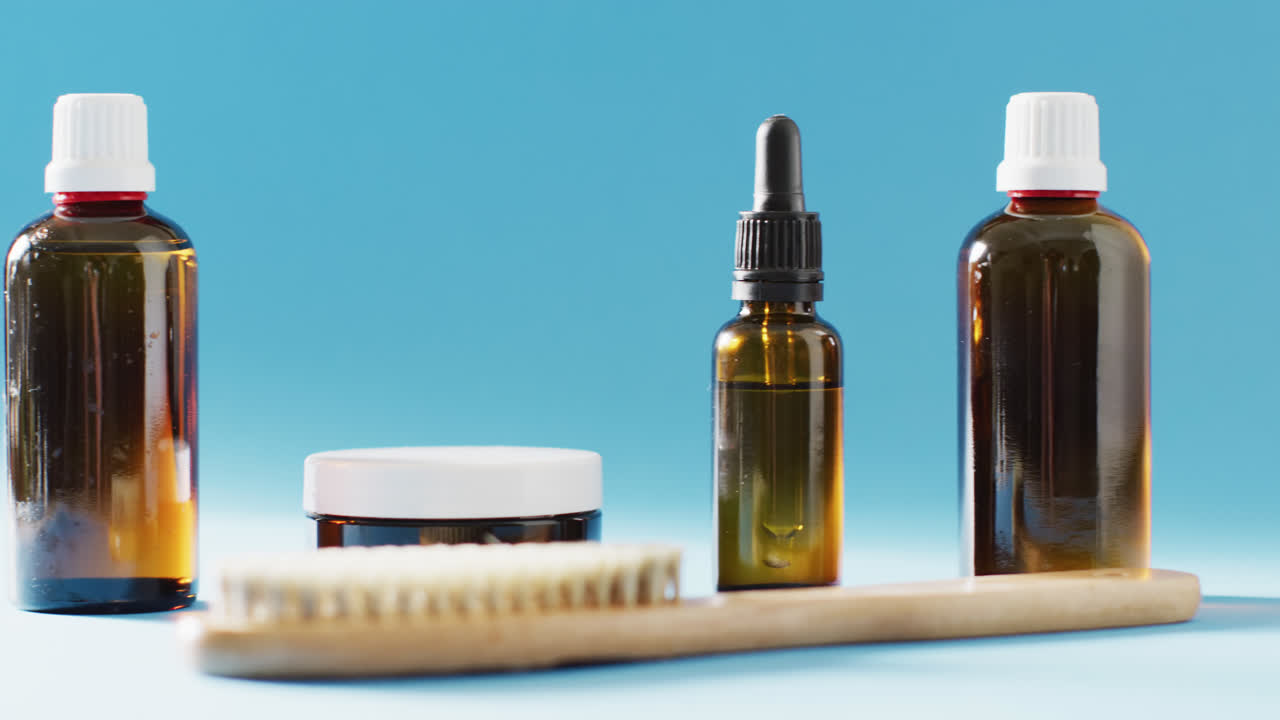 Close up of different beauty products on blue background with copy space