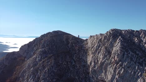 solo adventure of a female hiker hiking on a rocky mountain drone shot