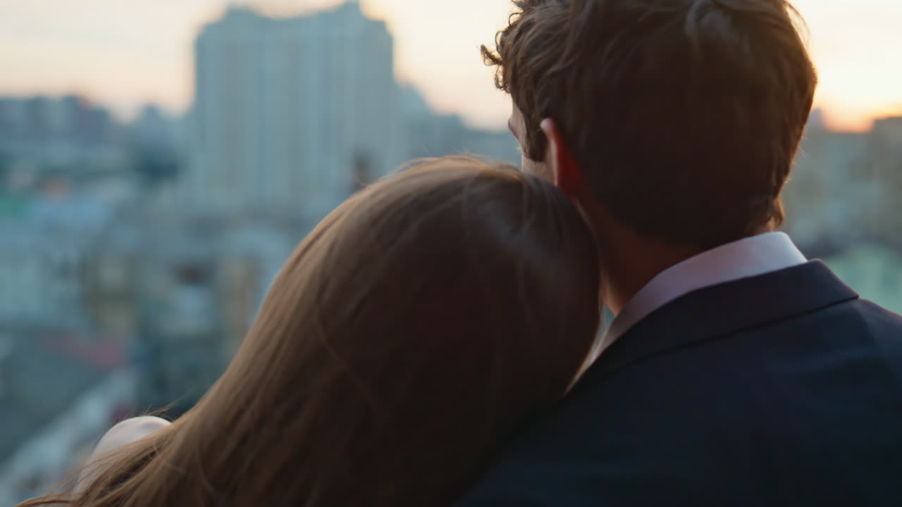 Romantic lovers spending date on terrace overlooking city sunset closeup