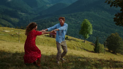 cheerful couple dance mountains. happy lovers have fun hold hands at nature view