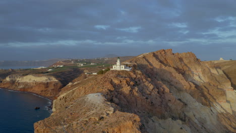 vista panorámica aérea del faro de akrotiri en santorini, grecia durante la puesta de sol