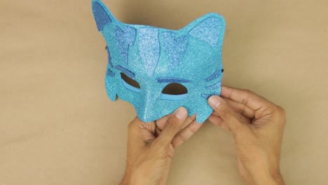 hands gluing last details, blue diamond foam catboy mask from pj masks for carnival