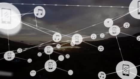 Animation-of-network-of-digital-icons-against-aerial-view-of-lanscape-with-mountains-and-sea