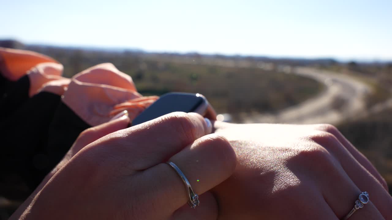Close-up of a smartwatch being adjusted outdoors during a sunny day fitness session