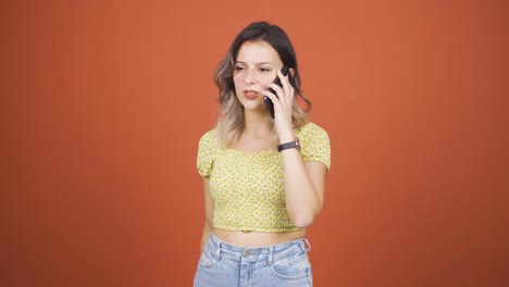 una joven enojada hablando por teléfono.