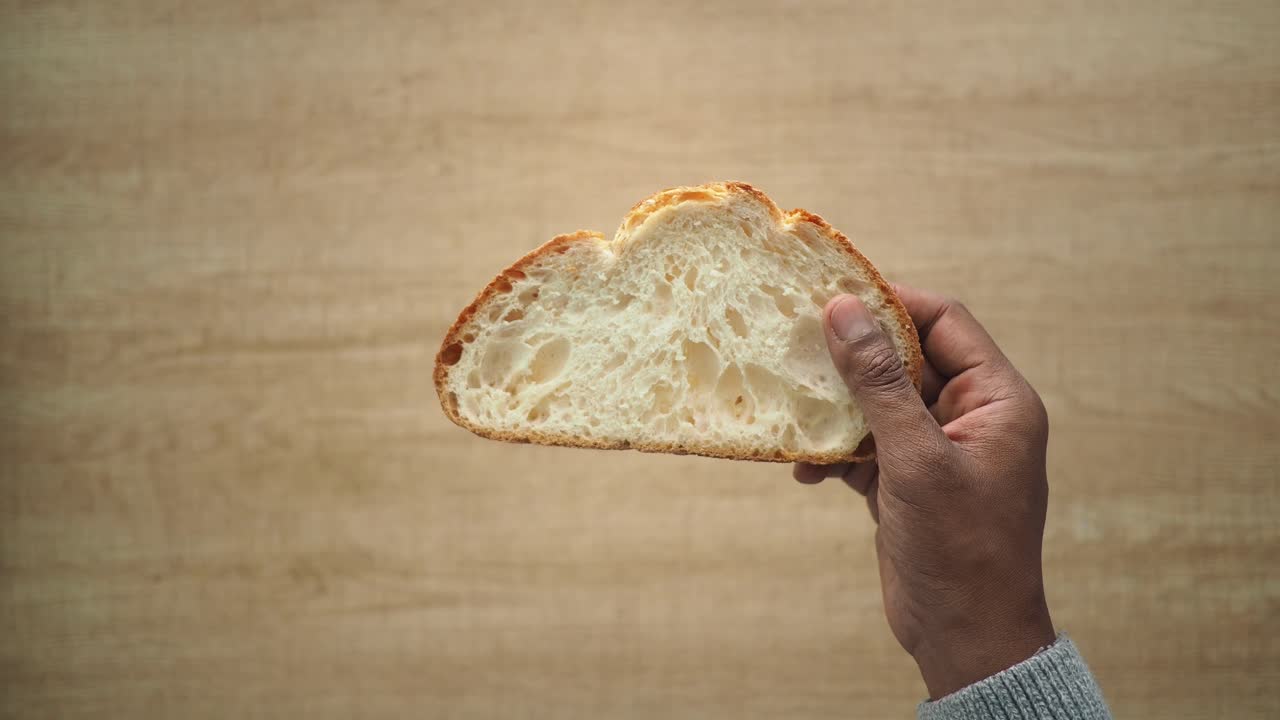 Person holding a slice of bread