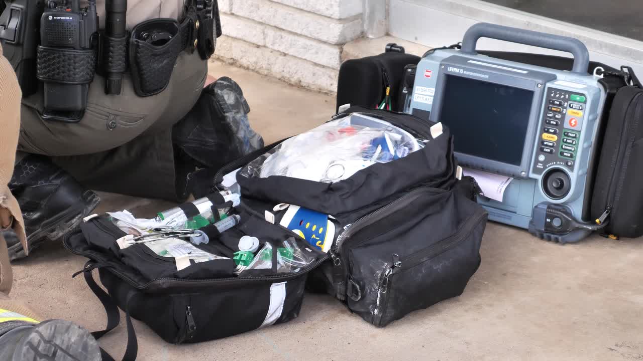 医療従事者が患者を治療しているときに開かれたファーストレスポンダーと医療機器バッグ