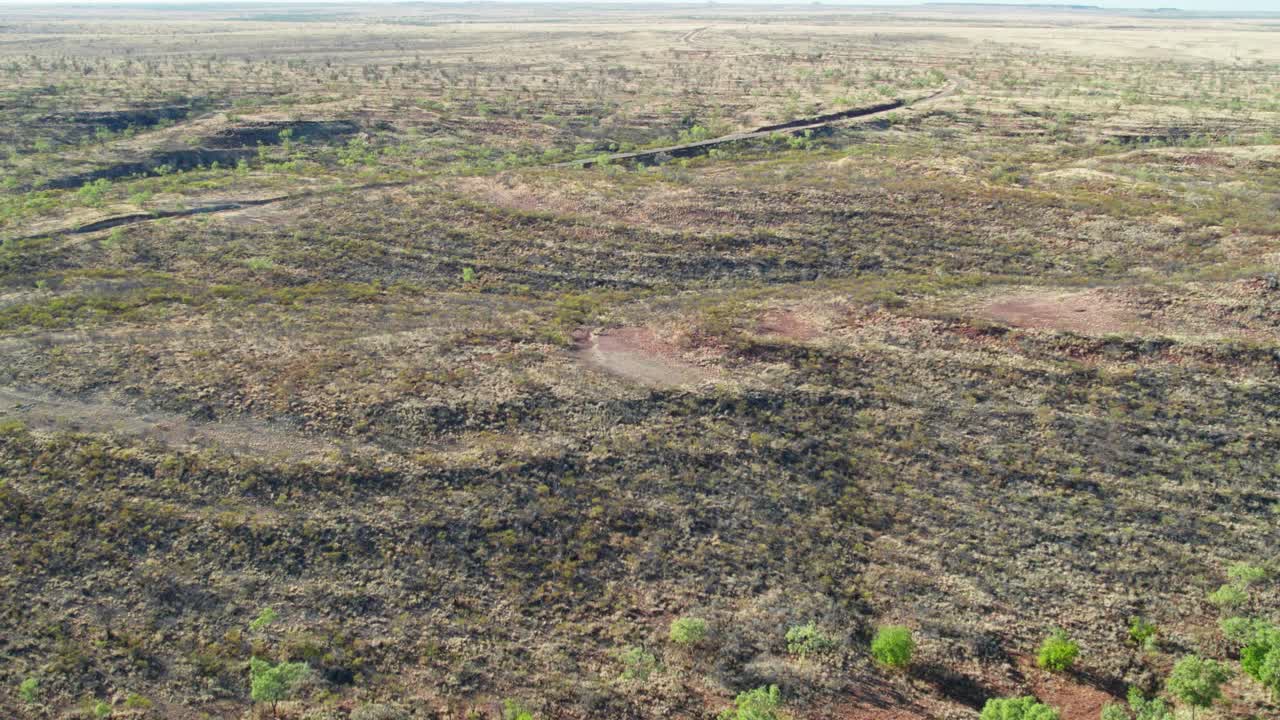 Aerial view over a plateau near Kalkarindji, with the Buntine Highway in the background, Gurindji, Northern Territory, Australia, August 2022.