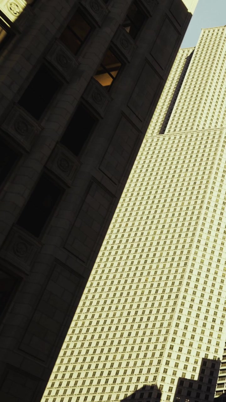 Alti edifici si ergono ravvicinati in una città in pieno giorno.