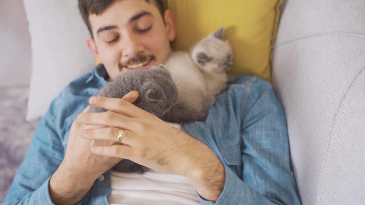 그 남자는 고양이와 함께 자고 있어요.