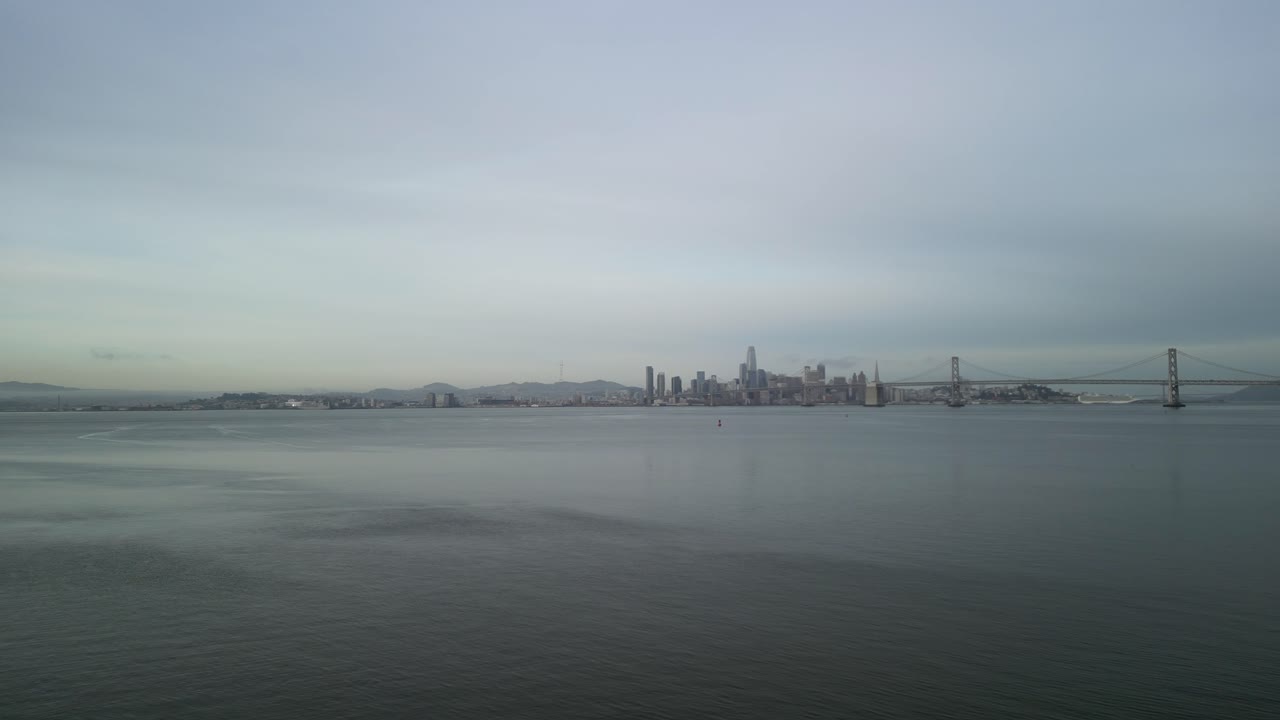A rotating drone shot displays the Bay Bridge in the distance of the San Francisco Bay.