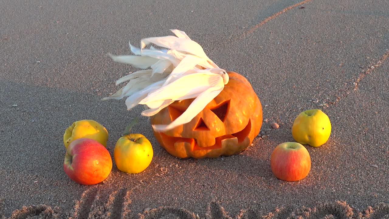 Labu Halloween seram. Tulisan Halloween di pasir pantai laut