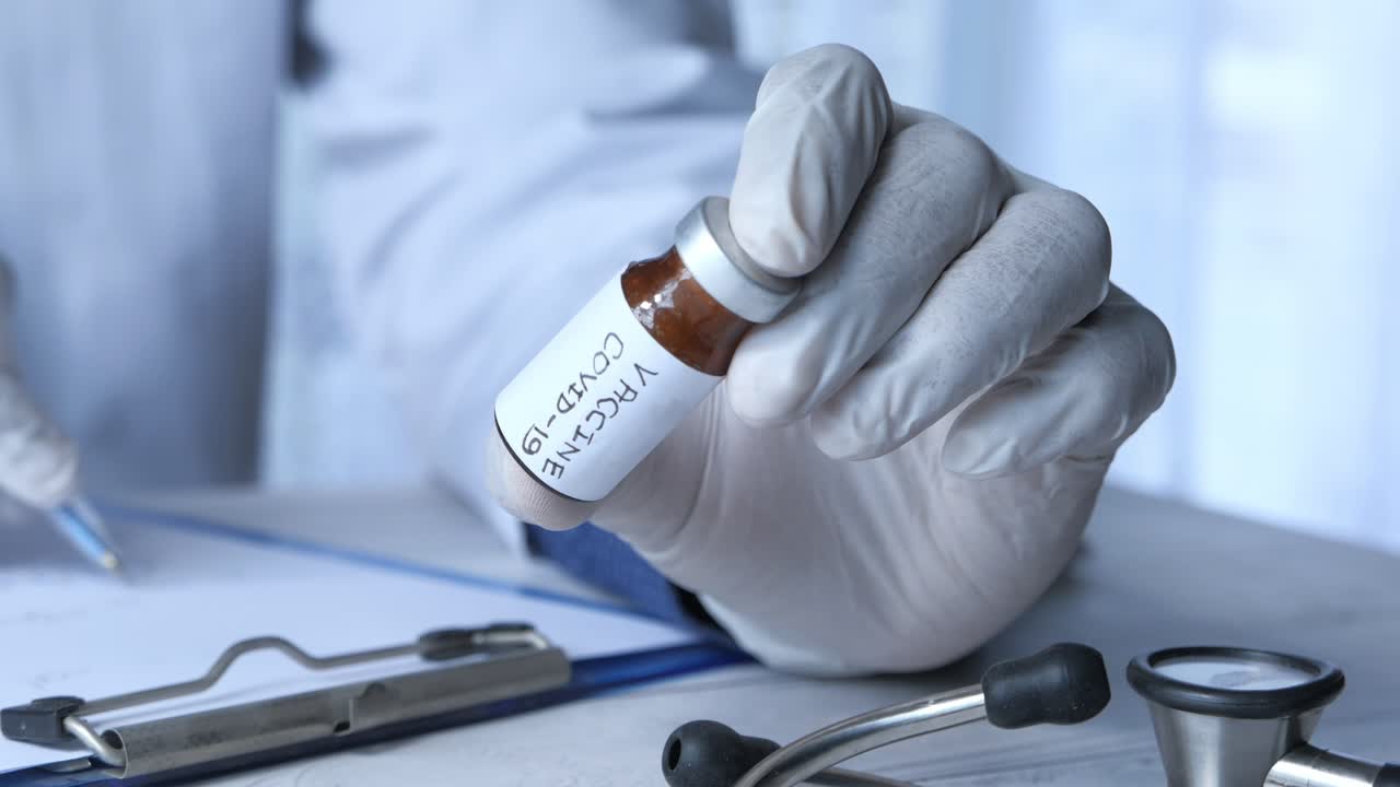 Medico che tiene una fiala di vaccino COVID-19