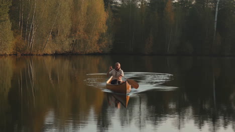 man canoeing on a serene autumn lake