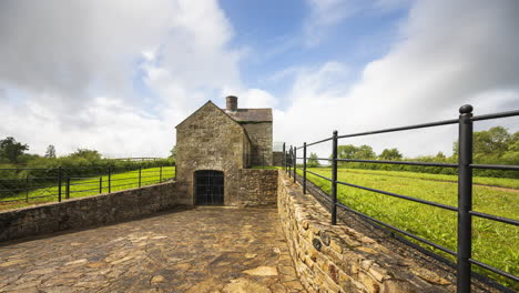 time lapse of a historical lime kiln building during the day with passing clouds in rural landscape ireland