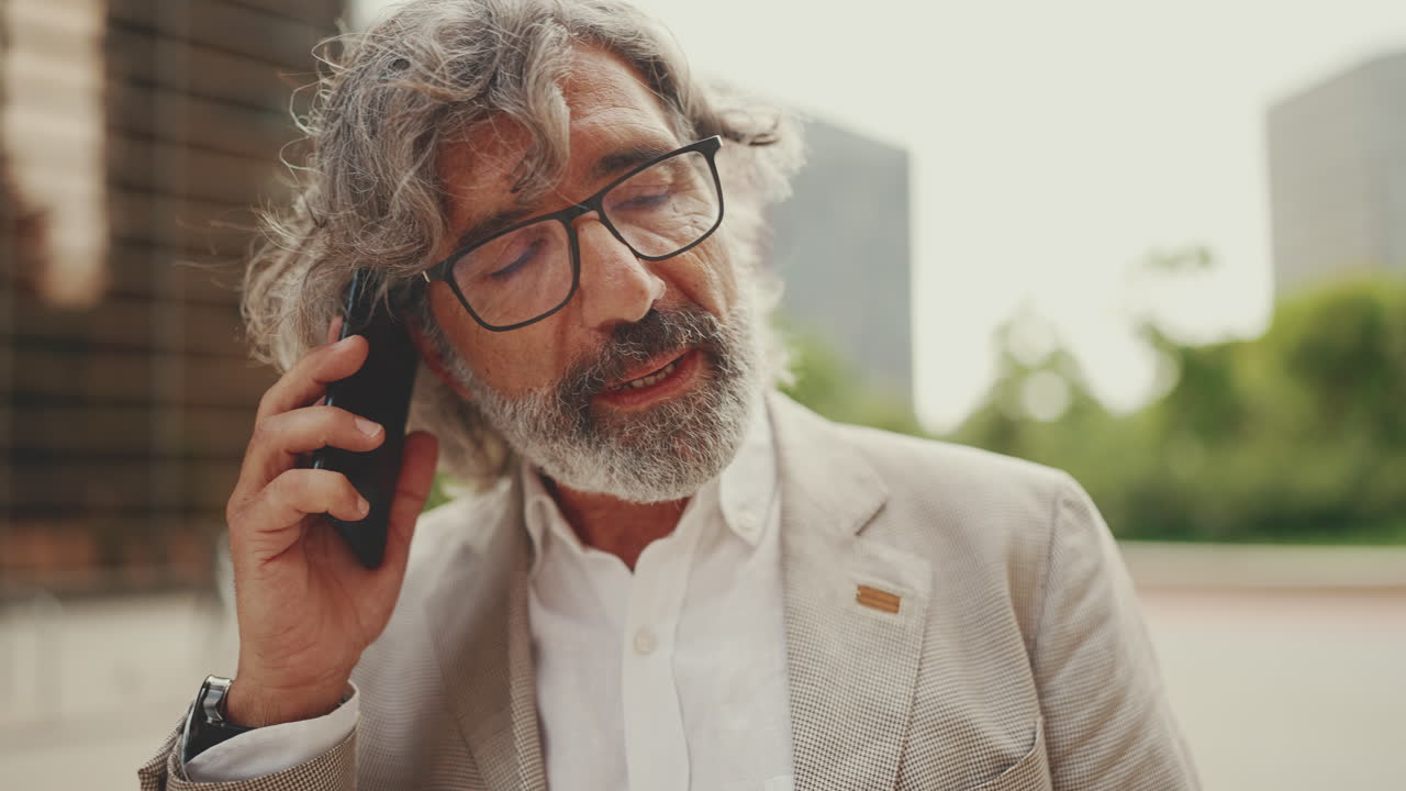 Middle-aged businessman on a phone call outdoors